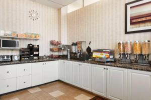 a kitchen with white cabinets and a counter top at Travelodge by Wyndham North Battleford in North Battleford