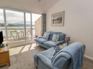 a living room with a couch and a chair at 25 South Snowdon Wharf in Porthmadog