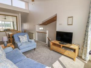 a living room with a couch and a television at 25 South Snowdon Wharf in Porthmadog