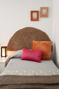 ein Bett mit einem großen Kopfteil und zwei Kissen in der Unterkunft MAR y SAL in Roquetas de Mar