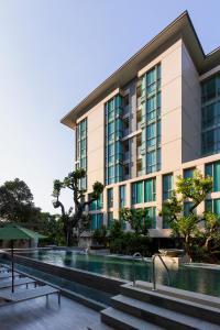 a building with a swimming pool in front of it at ANA Park Chiang Mai in Chiang Mai