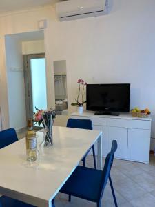 une salle à manger avec une table blanche et des chaises bleues dans l'établissement Amarcord, à Pouzzoles