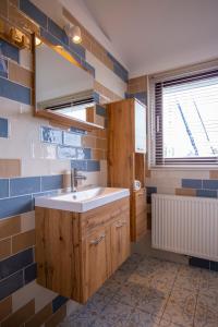 een badkamer met een wastafel en blauwe en witte tegels bij Unieke woonboot in Harlingen in Harlingen