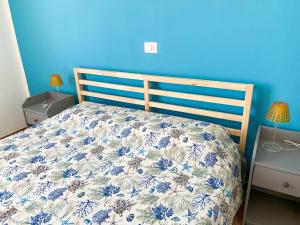 1 dormitorio con 1 cama con pared azul en Conero-30 mt dal Mare, Balcone V i s t a Mare e Spiaggia di sabbia en Porto Potenza Picena