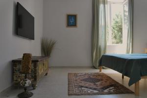 a living room with a tv and a table and a rug at Apartma Na Trati in Izola