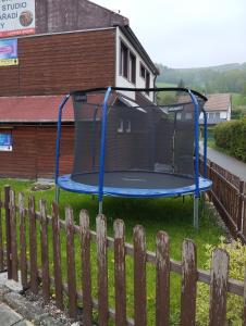 um trampolim num quintal ao lado de uma cerca em Apartmány U Aničky em Lipova Lazne