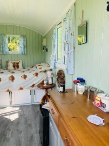 a bedroom with a bed and a wooden counter at Bells Meadow Shepherds Hut in Kings Lynn