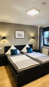 2 bedden met blauwe kussens in een slaapkamer bij Rheinländer Seehotel in Leverkusen