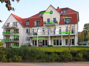 a large white building with green words on it at App Seaside in Insel Poel