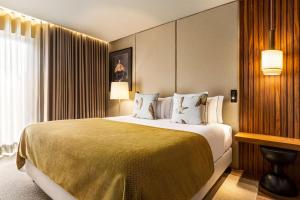 a hotel room with a large bed and a window at Fontinha Porto, Trademark Collection by Wyndham in Porto