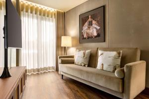 a living room with a couch and a window at Fontinha Porto, Trademark Collection by Wyndham in Porto
