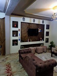 Una sala de estar con un sofá y un televisor de pantalla plana. en Big , Pyramid view, en El Cairo