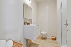 een witte badkamer met een toilet en een wastafel bij Charming getaway in the historical city center in Brugge