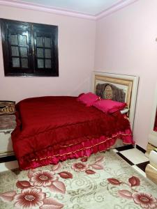 a bedroom with a red bed with a red blanket at Big , Pyramid view in Cairo