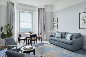 a living room with a couch and a table at Bournemouth Highcliff Marriott Hotel in Bournemouth