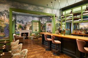 a bar in a restaurant with a painting on the wall at Bournemouth Highcliff Marriott Hotel in Bournemouth