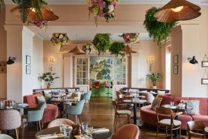 a restaurant with tables and chairs and flowers at Bournemouth Highcliff Marriott Hotel in Bournemouth