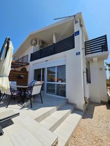 a house with a patio with a table and chairs at Studio apartment PEGY in Vir