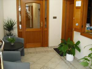 un vestíbulo con puerta, mesa y plantas en Sport hotel POMI, en Harrachov