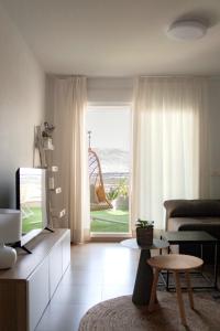 ein Wohnzimmer mit einem TV und Meerblick in der Unterkunft MAR y SAL in Roquetas de Mar