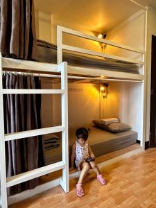 a little girl sitting on the floor in a bunk bed at 84 Gallery in Chiang Mai