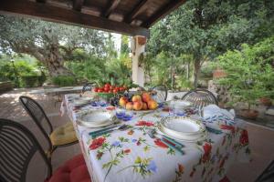 a table with plates and bowls of fruit on it at DONNA CATERINA HOUSE in Pietraperzia