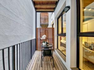 a balcony with a table on a wooden deck at Upmarket and Stylish Apartment With Rooftop Pool. in Cape Town
