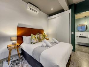 a bedroom with a large bed and a bathroom at Upmarket and Stylish Apartment With Rooftop Pool. in Cape Town