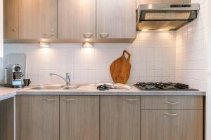 a kitchen with a sink and a stove top oven at Magnificent Apartment with Great Panoramic Seaview in De Haan