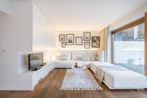 sala de estar blanca con sofá blanco y TV en Modern renovated apartment with terrace and parking, en Knokke-Heist