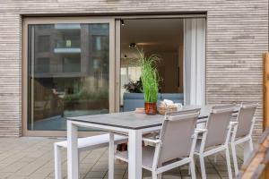 una mesa blanca y sillas en un patio en Brand new holiday home with high-end finishing and private parking space, at a stone's throw from the beach en Ostende