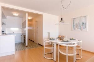 a kitchen and dining room with a white table and chairs at Stunning Seaview apt on 7th floor at beachfront in Knokke-Heist