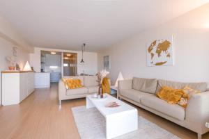 a living room with two couches and a table at Stunning Seaview apt on 7th floor at beachfront in Knokke-Heist
