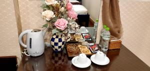 een tafel met een vaas met bloemen en een koffiezetapparaat bij Milan Diamond Hotel in Vung Tau