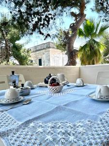 a table with a blue and white table cloth on it at Dimora dei pini in Leuca