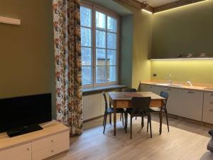 a room with a table and a kitchen with a television at Creton apartment -La casa nel cuore della città- CIR 0121 in Aosta