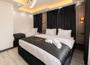 a hotel room with two beds with white sheets at Selia SUİTES in Trabzon
