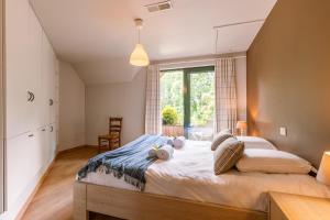 Un dormitorio con una cama grande con dos animales de peluche. en Peacefully located villa with stunning garden and hot tub, en Oostkamp