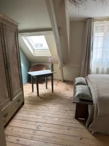 a bedroom with a bed and a table and a window at La maison du tripot in Honfleur