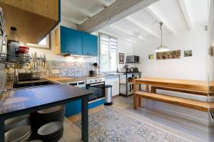 cocina con armarios azules y mesa de madera en Gîte du petit Val du Gers en Savignac-Mona