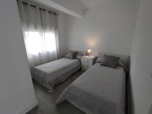 a bedroom with two beds and a window at apartamento vacacional in Calpe