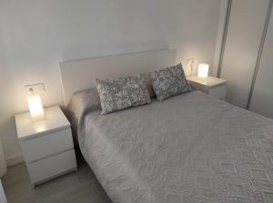 a bedroom with a bed with two night stands and two lamps at apartamento vacacional in Calpe +6 photos