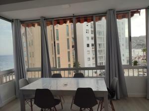 a table and chairs in a room with a large window at apartamento vacacional in Calpe