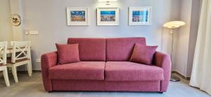 a pink couch with two pillows in a living room at Malaga Lodge Apartments in Málaga