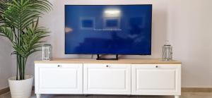 a tv sitting on top of a white cabinet at Malaga Lodge Apartments in Málaga