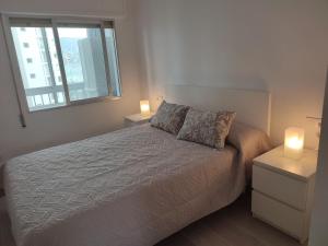 a bedroom with a bed with two night stands and two lamps at apartamento vacacional in Calpe
