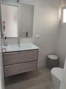 a bathroom with a sink and a toilet and a mirror at apartamento vacacional in Calpe