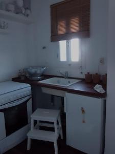 une cuisine avec un comptoir, un évier et un tabouret dans l'établissement Ageri Home, à Karavostasi