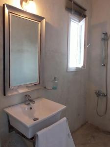 La salle de bains blanche est pourvue d'un lavabo et d'une fenêtre. dans l'établissement Ageri Home, à Karavostasi