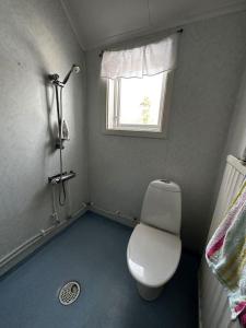 a small bathroom with a toilet and a window at Hedsjövägen 23 med 350m sandstrand 